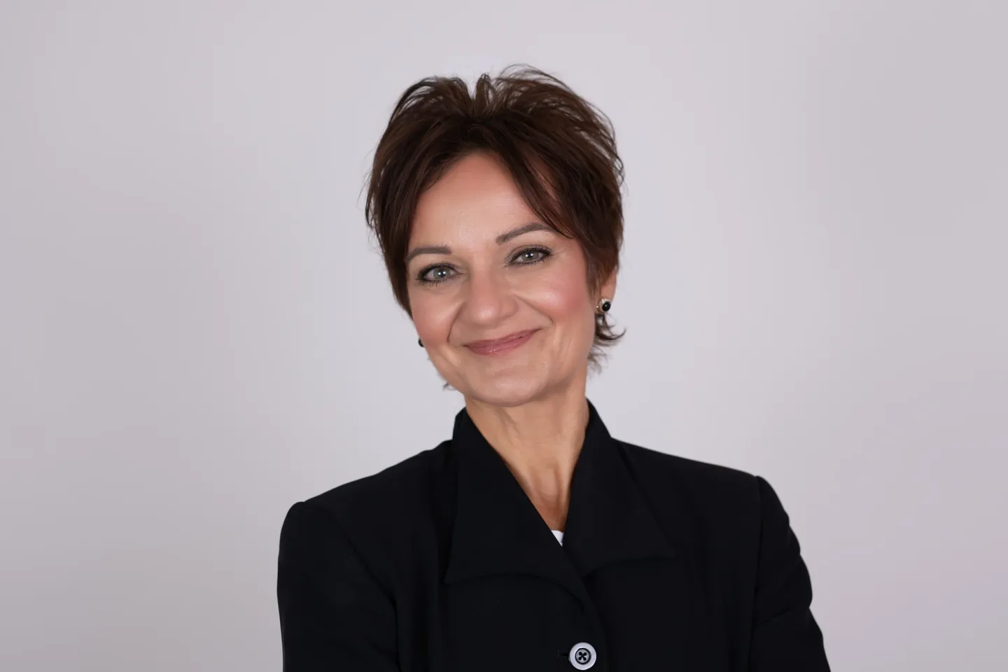 A woman in black jacket smiling for the camera.